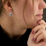 ragazza di profilo in posa che indossa orecchini pendente zaffiro e diamanti di comete gioielli orb 949